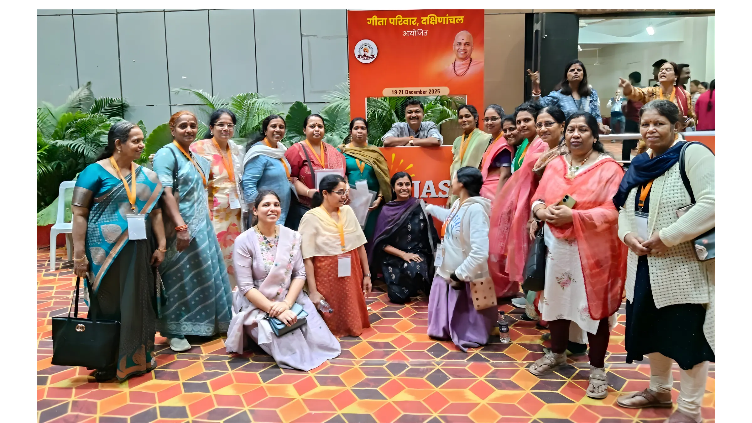 गीता परिवार दक्षिणांचल के आयोजन में पंजीकरण मंच के सामने एकत्र सेविकाओं का समूह चित्र।